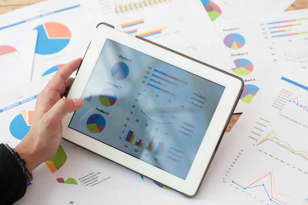 ipad and papers showing graphs